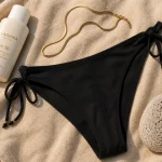 Femme en bikini brésilien : bikini noir taille haute échancré
